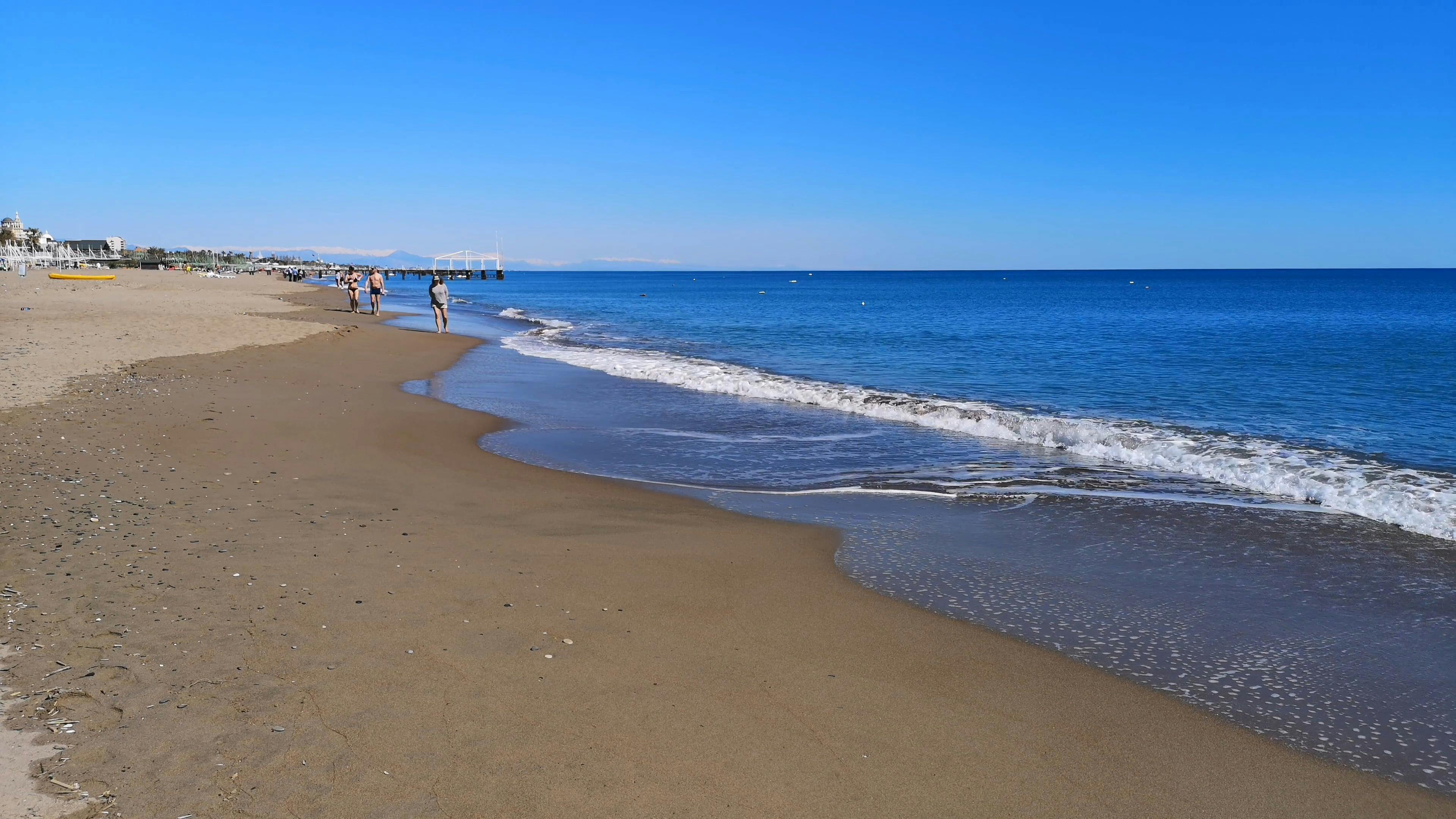 Gente Caminando Por La Playa · Vídeo de stock gratuito