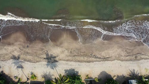 Slow Motion Footage Of Waves, Lapping On Sandy Shores From Above