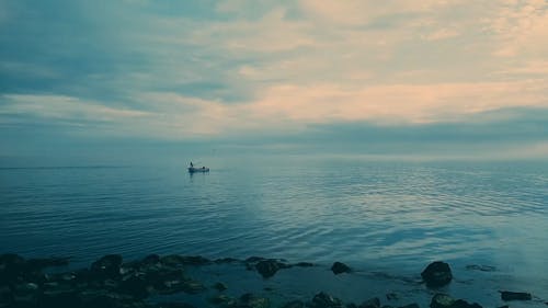 Uma Pessoa Em Um Barco Pescando Em águas Calmas