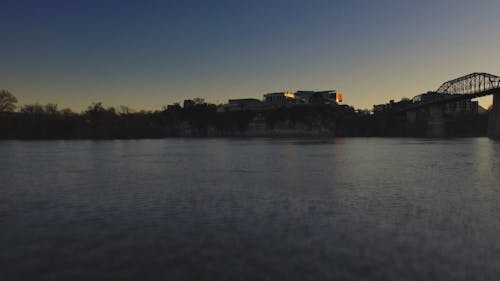 View From River To City At Sunset