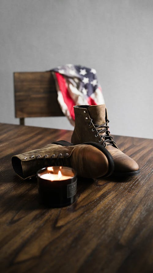 Lighted Candle And Boots On Table