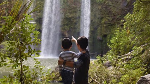 父亲和孩子看着瀑布