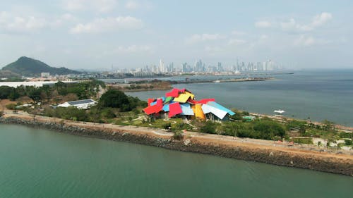 Aerial Footage Of Building With Distinct Architectural Design In  A Coastal City And Its Surrounding Landscape