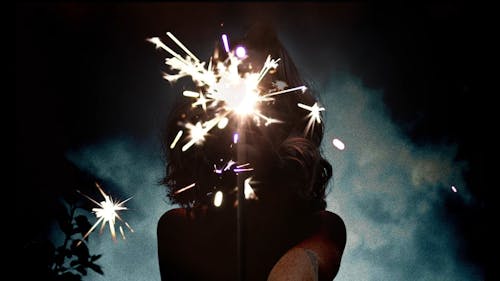 Low- Angle Shot Of A Woman Holding A Lit Sparkler
