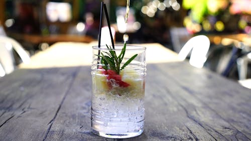 Liquid Being Poured Into A Glass Of Iced Drink