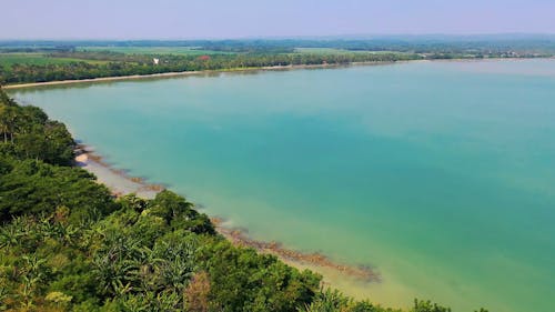 Aerial View Of A Vast Agricultural Land Near Body Of Water