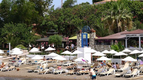 Personas En Camas De Playa Plegables Disfrutando Del Sol