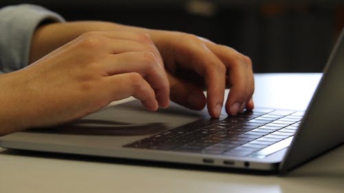 A Human Hand Busy Working On a Computer Laptop