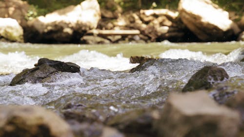 A River Flowing Through A Bed Of Rocks