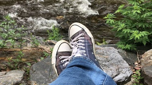 A Persons Feet Resting On A Rock