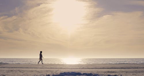 ビーチに沿って歩く女性のローアングル映像