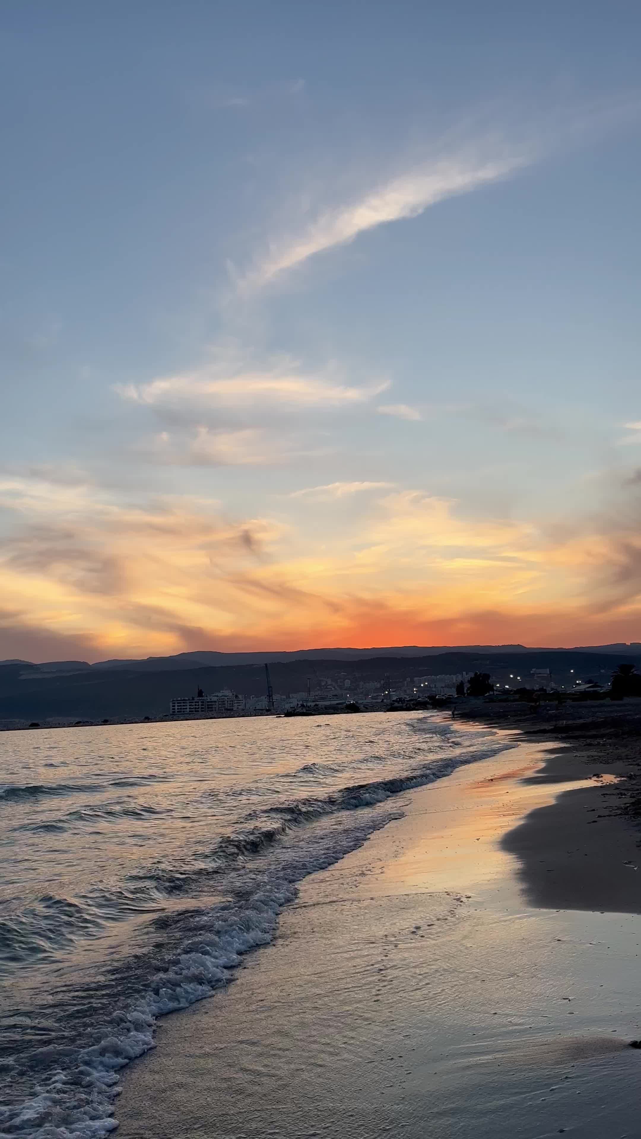 the sun sets over the beach and the ocean 26050378