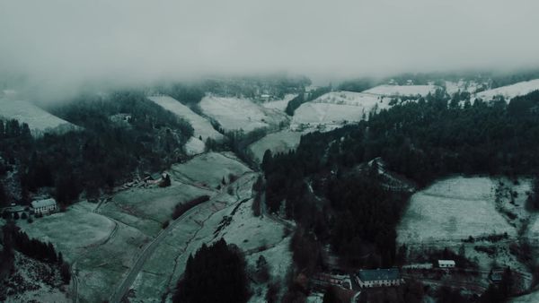 Aerial view of a snowy mountain landscape with a road and trees Free ...