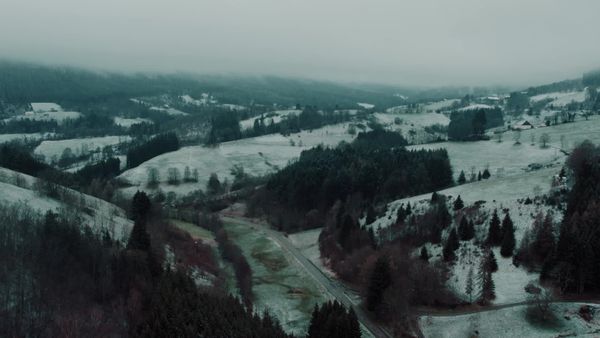 Aerial view of a snowy mountain landscape with a road and trees Free ...