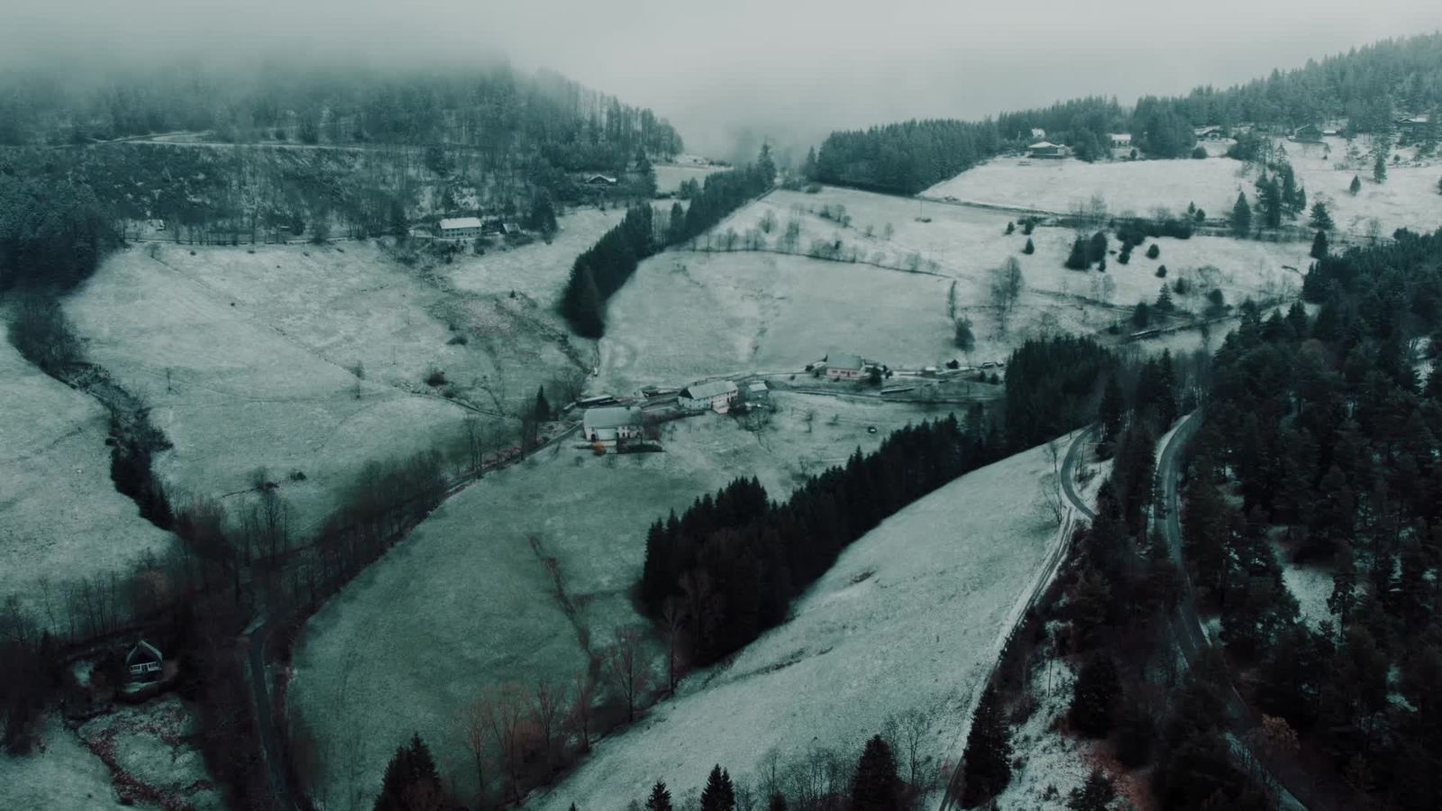 Aerial view of a snowy mountain landscape with a road and trees Free ...