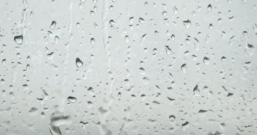 Drops Of Water Dripping On A Glass Surface