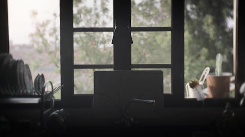 man drinking water in a dark kitchen