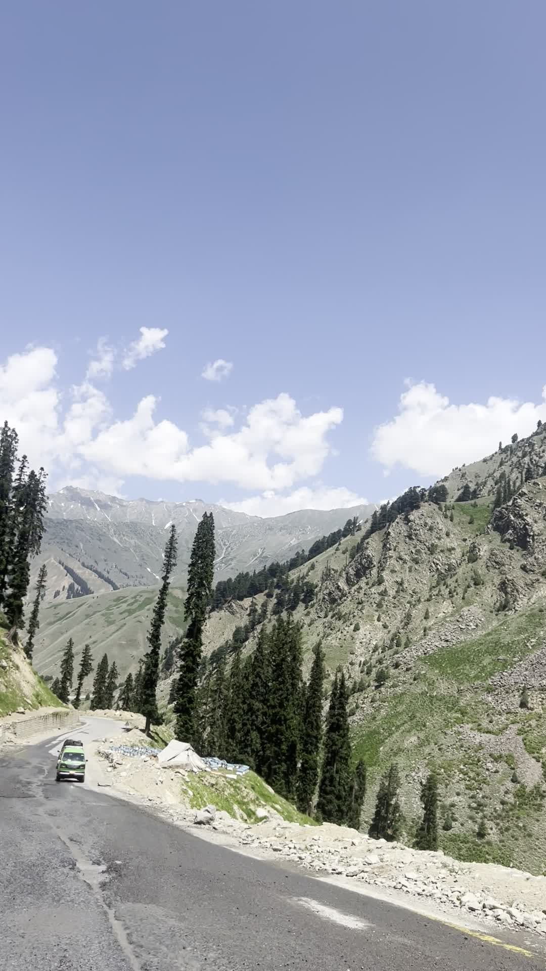 A car driving down a road with mountains in the background Free Stock ...