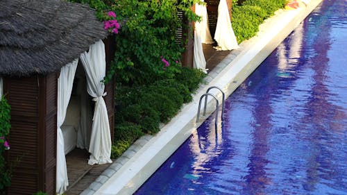 Femme Nageant Dans Une Piscine Bordée De Cabanes