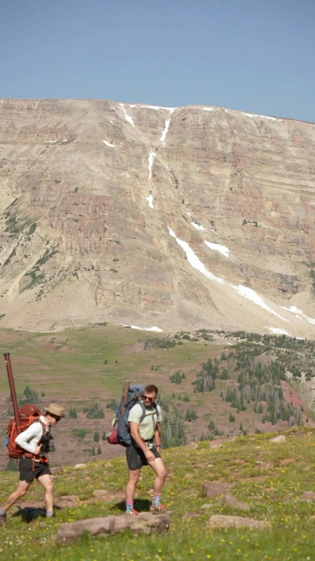two people hiking up a mountain with a mountain in the background 27393701