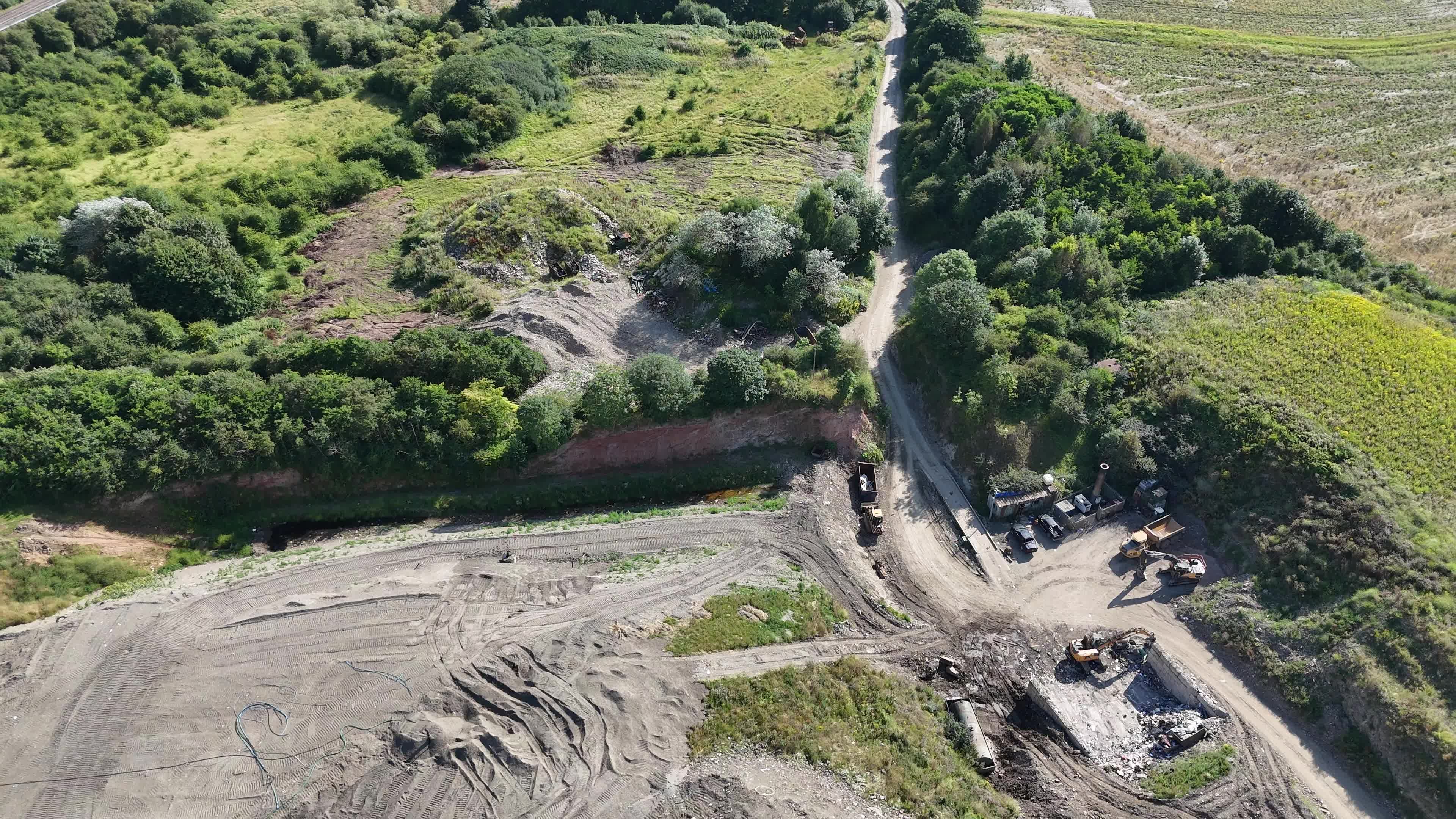 An aerial view of a field with a road and trees Free Stock Video ...