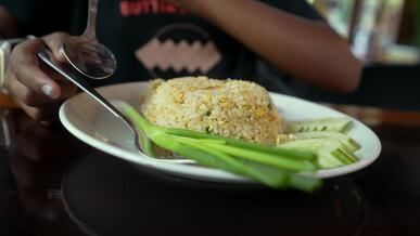a plate of rice with vegetables and a fork