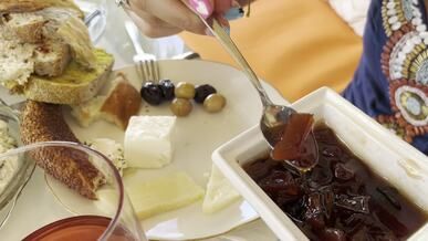 a woman is eating a plate of food with bread and cheese