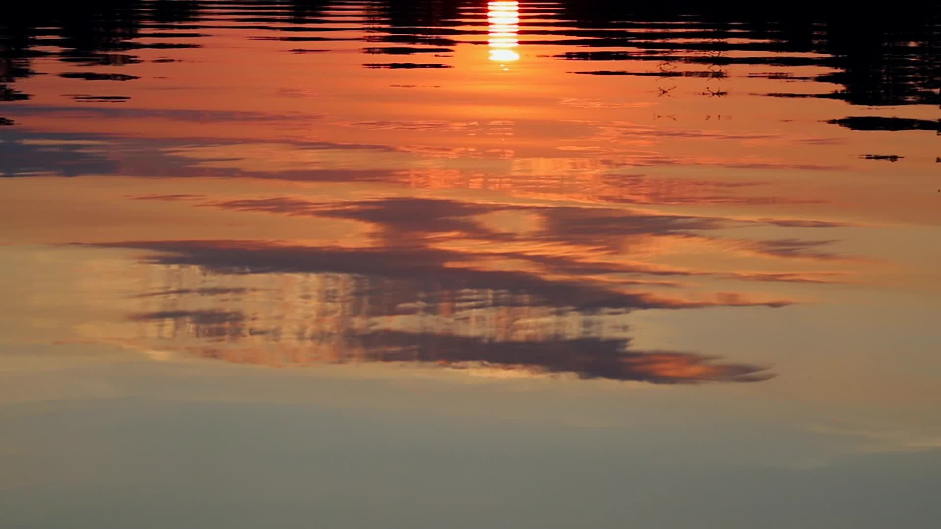 The sun sets over the water with clouds in the sky Free Stock Video ...