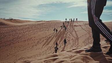 a group of people walking through the desert