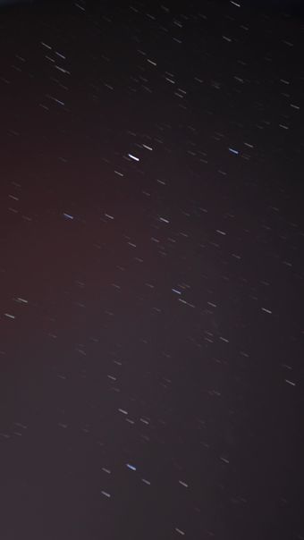 星轨延长，同时一颗人造卫星划过天际视频素材