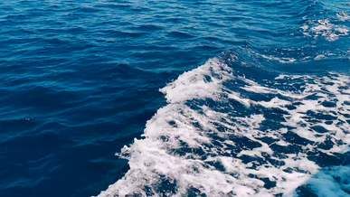 a speedboat props white wash on a blue water