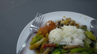 a plate of food with rice vegetables and meat