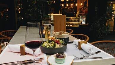 a table with a glass of wine and a plate of food