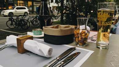 a table set for two with a glass of wine and a knife and fork