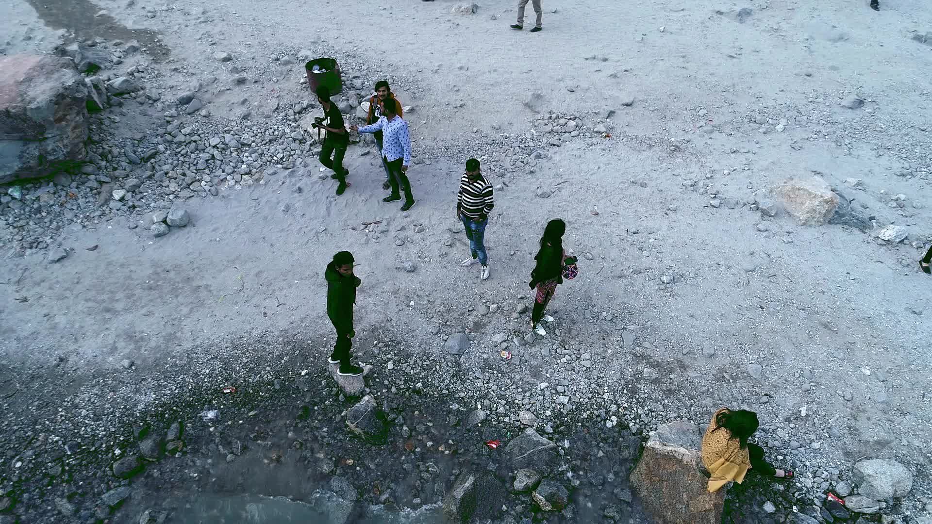 Drone flight over the Hunza valley, a long blue river below with boats ...