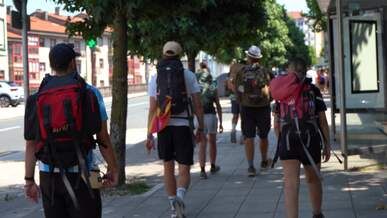 a woman with a backpack walking down a sidewalk