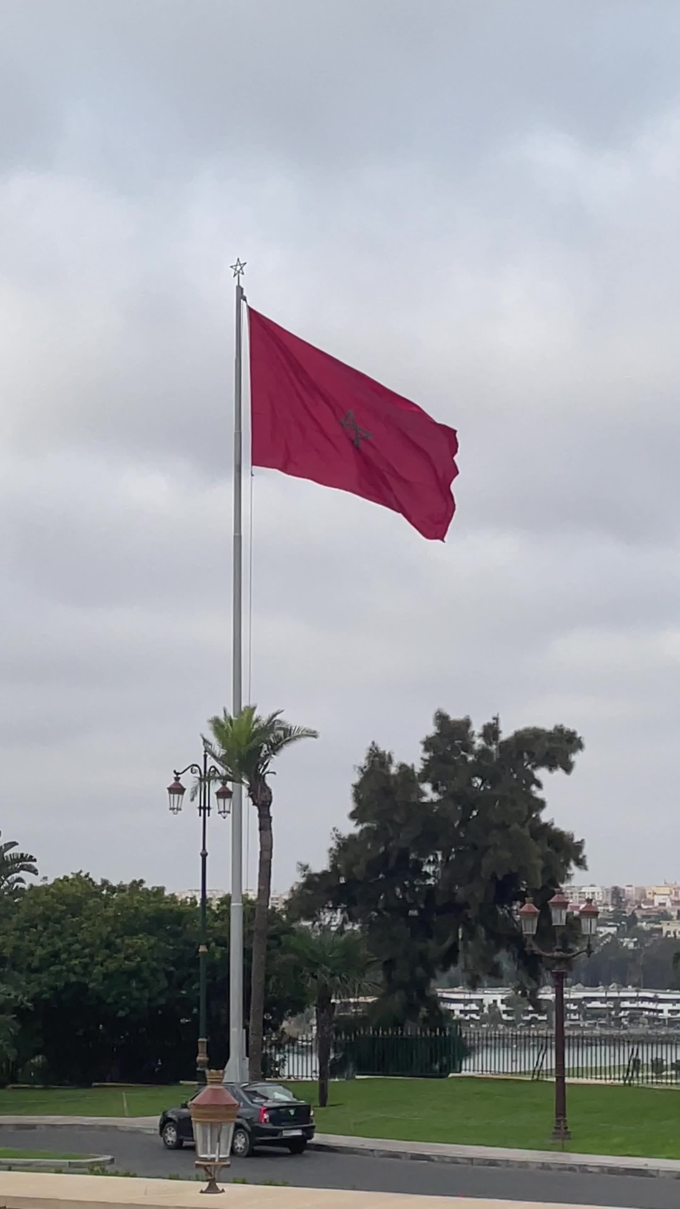 A red flag flying over a park with a fountain Free Stock Video Footage ...