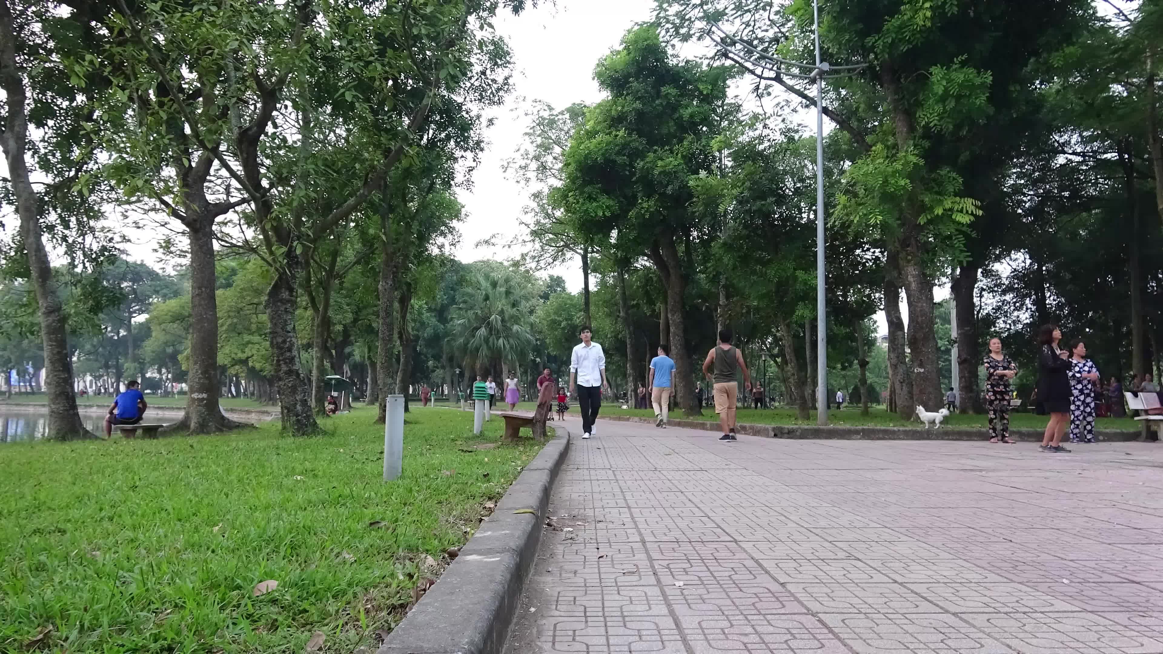 a group of people walking down a paved walkway 27922186