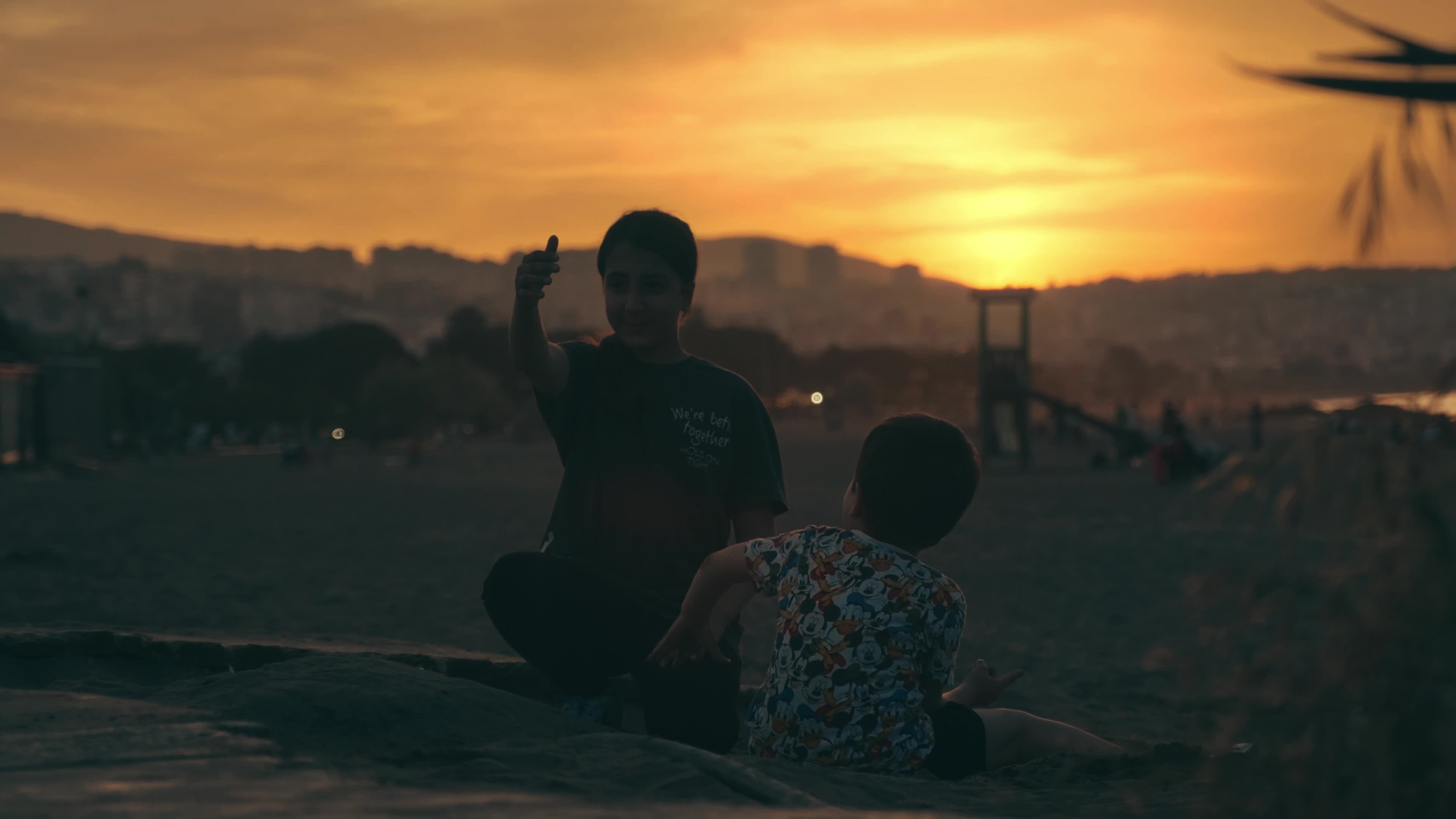 Two people sitting on the beach at sunset Free Stock Video Footage ...