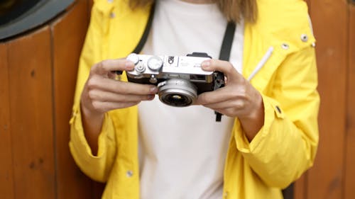 Woman In Yellow Jacket And Red Beanie Taking A Photo