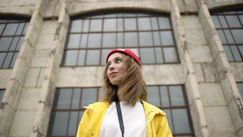 Low Angle Shot Of Woman Standing In Front Of A Building 