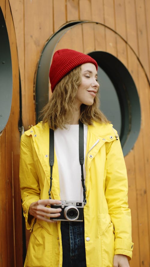 Mujer En Gorro Rojo Y Chaqueta Amarilla Con Cámara