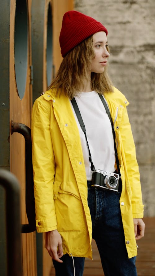 Woman In Red Beanie And Yellow Jacket With Camera