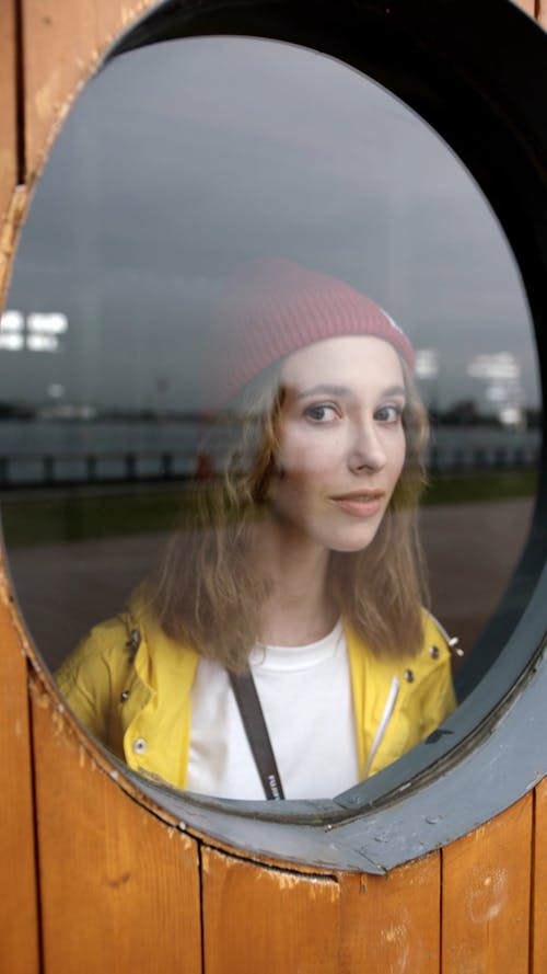 Woman Lookin Through A Circular Glass Window