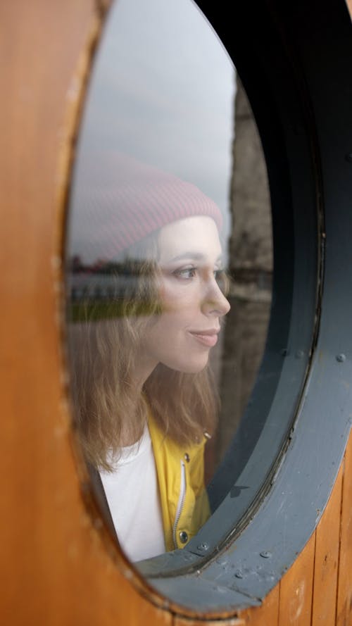 Woman Looking Through A Glass Window