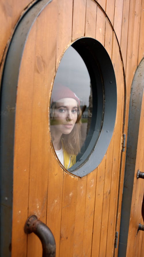 Woman Looking Through A Bull's Eye Window