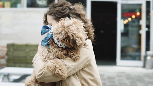 Женщина идет по улице со своей собакой