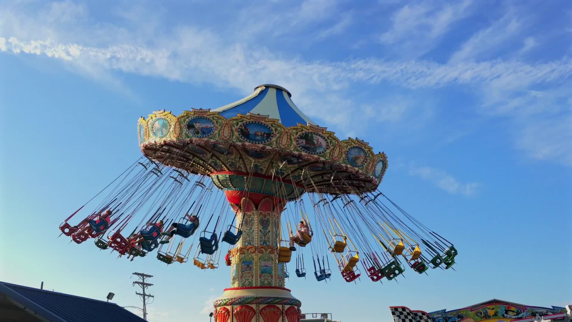 A carnival ride with people on it and a blue sky Free Stock Video ...