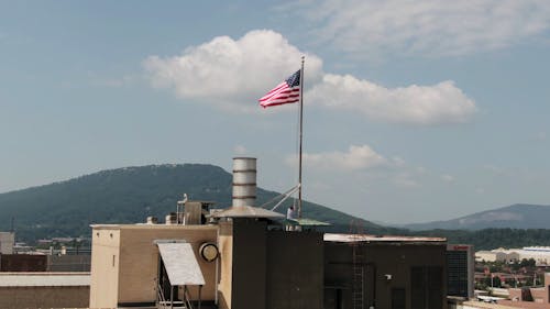 Withdrawing The American Flag From Its Pole On Top Of A Building