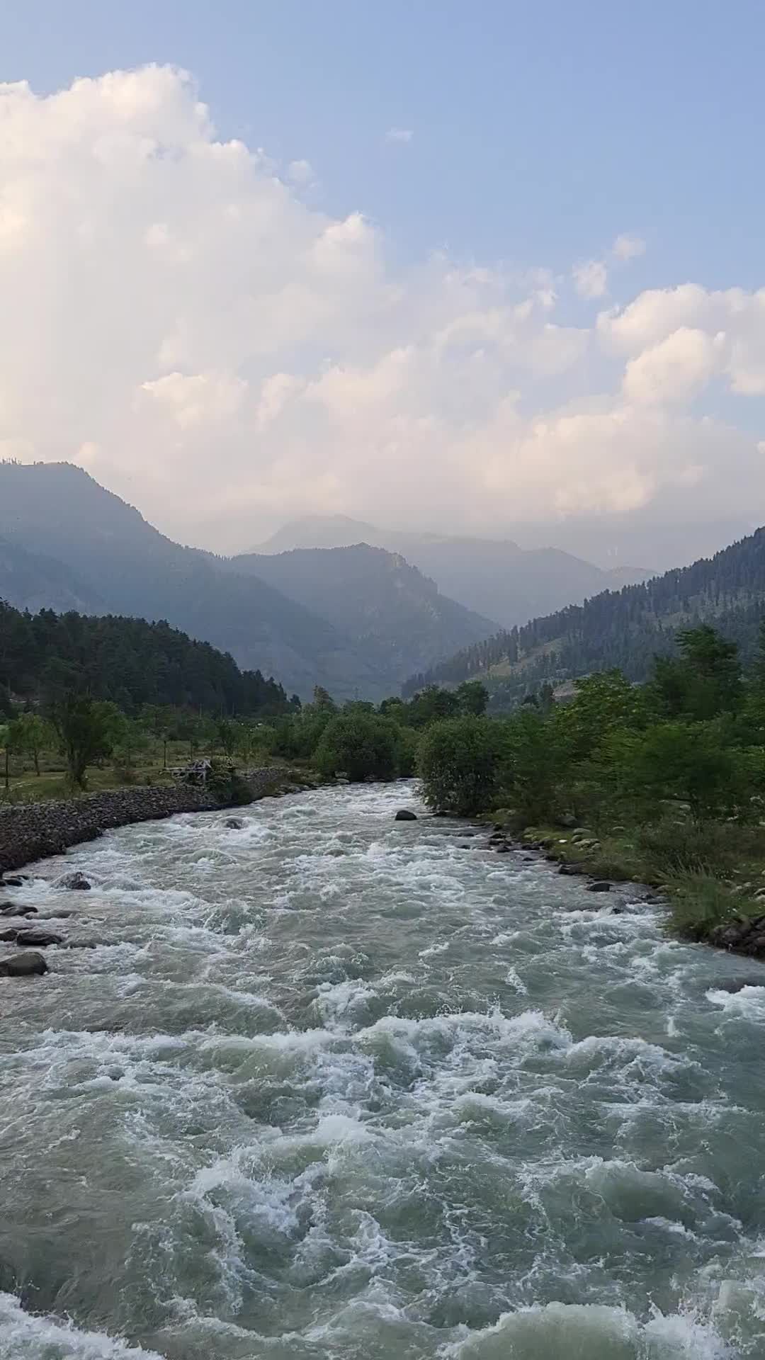 A river running through a valley with mountains in the background Free ...
